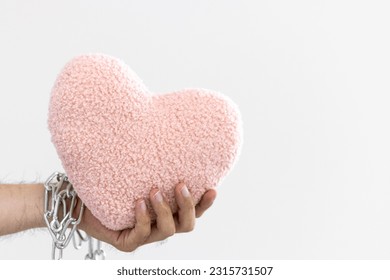 Male hand holding an unchained heart