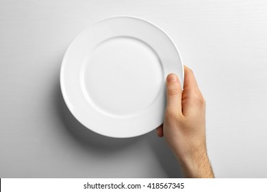 Male Hand Holding White Plate, Isolated On White