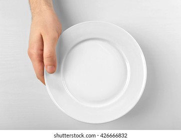 Male Hand Holding White Plate, Isolated On White