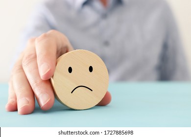 male hand holding wooden cube with sad face. concept of anxiety, stress or sad emotions - Shutterstock ID 1727885698