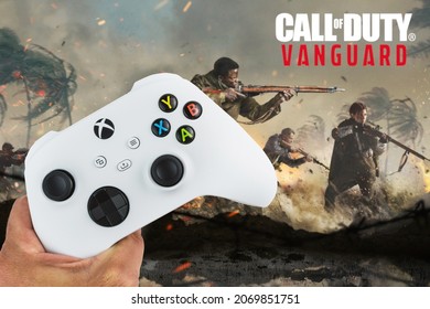 Male hand holding a Xbox Series S White Controller with Call of Duty Vanguard game blurred in the background. Rio de Janeiro, RJ, Brazil. November 2021.