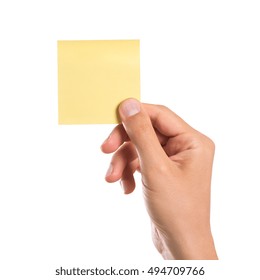 Male hand holding a yellow empty sticky note isolated on white background. Man hand holding blank yellow notepaper on white background. Close up of hand showing square post it.