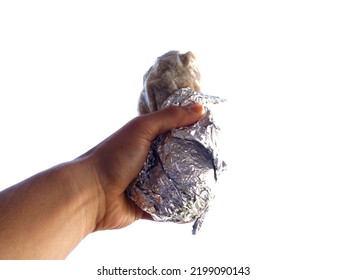 Male Hand Holds Burrito Wrapped In Tinfoil In The Air On White Background.