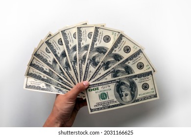 Male Hand Holds Few Hundreds US Dollars On White Background: 100 Usd Currency Banknotes. Inflation, Business, Economics And Finance Theme.