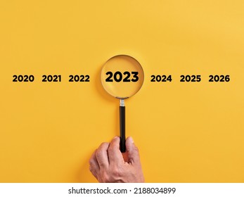 Male hand holds a magnifier focusing on the year 2023. Focus on new business goals, plan and strategy of the year 2023 concept. - Shutterstock ID 2188034899