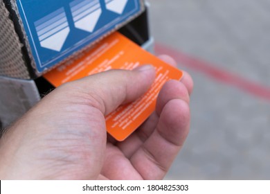 A Male Hand Holds An Orange Card Near An Information Reader. Concept For Scanner Electronic Ticket, Badge. Selective Focus.