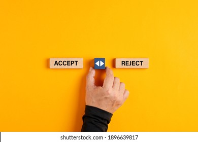 Male Hand Holds A Wooden Cube With Arrow Icon Between The Options Of Accept Or Reject. The Decision Or Choice Between Accepting Or Rejecting.

