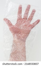 Male Hand Inside A Transparent Wrap Bag. Hand Of A Male Wrapped In Protective Plastic Film With Bubble.