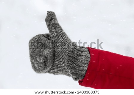 Male hand in knitted mittens.Man showing thumbs up.Winter love concept.