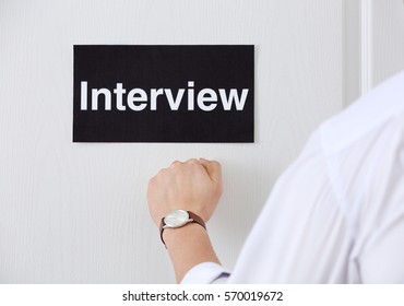 Male Hand Knocking On Door With Black Signboard