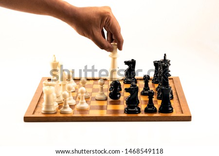 Male hand moving the white chess queen during the game of chess. Isolated on white.