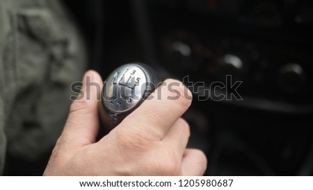 Male hand on gear lever, manual transmission, close up, selected focus.