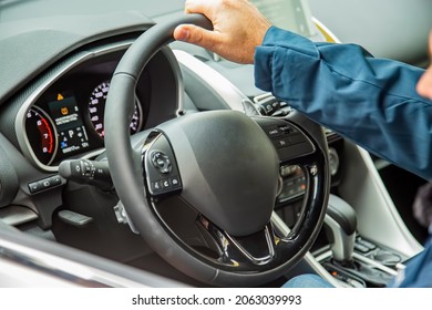 Male Hand On The Steering Wheel Of A Modern Car. Multifunction Steering Wheel And Driver's Panel. No Face