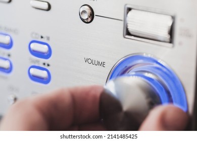 Male hand is on a volume control knob, close up-photo with selective soft focus