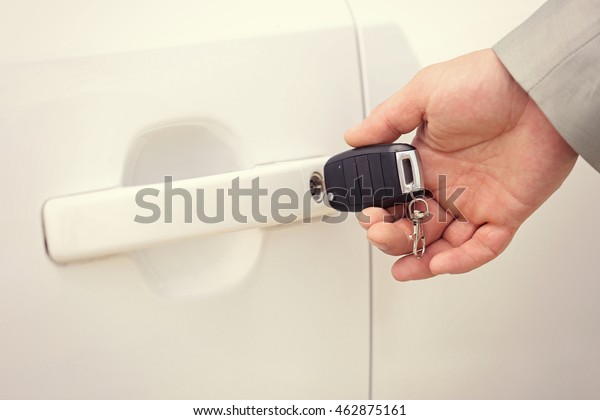 Male hand opening car door\
with key