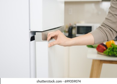 Male Hand Is Opening White Refrigerator Door