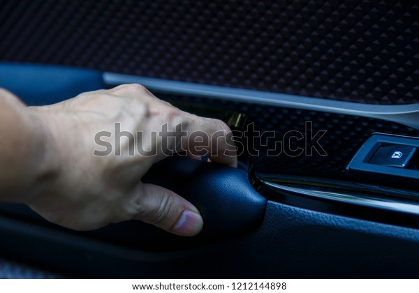 Male hand opens the inner door handle, modern\
car interior