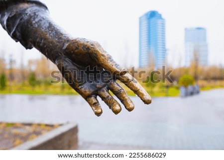 Male hand palm bronze sculpture in rain gives hand, help concept. Close-up
