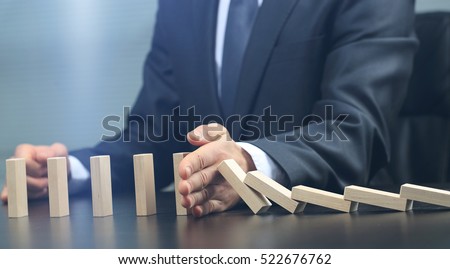 male hand placing wooden block on a tower. planing and strategy concept