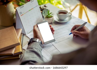 Male Hand Of Planner Writing Daily Appointment On 2020 Calendar Book, Working Space At Home. Asian Man Plan And Noted Schedule (holiday Trip) On The Diary At Office Desk. Calendar For Planner Concept