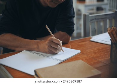 Male hand of planner writing daily appointment On Calendar book, working space at home. Man plan and noted schedule (holiday trip) on diary and using smartphone at office desk. Planner concept.