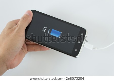 male hand plugging in the wall electtric plug of his smartphone in a socket Stock photo © 