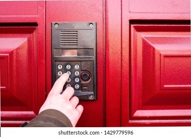 Male Hand Presses A Button On Doorbell And Intercom. Traveling Salesman Ringing To The Flat