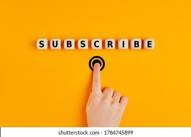 Male Hand Pressing Subscription Button With The Word Subscribe Written On Wooden Blocks. Online Registration Concept.