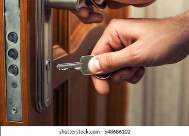 Male hand puts the key in the keyhole - Shutterstock ID 548686102