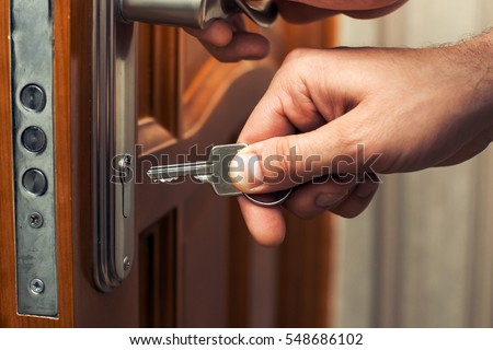 Male hand puts the key in the keyhole