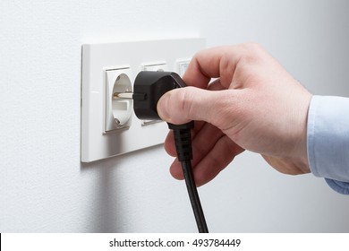 Male Hand Puts Plug In The Socket, Closeup Shot