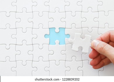 male hand putting the last piece in the puzzle - Powered by Shutterstock