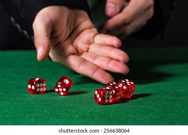 Male Hand Rolling Five Dice On Green Felt