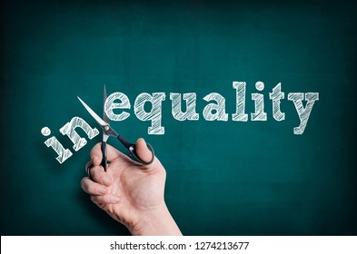 Die männliche Hand mit Schere schneidet das Wort Gleichheit von Ungleichheit ab