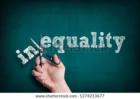 The male hand with scissors cuts word Equality from Inequality