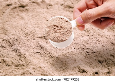 Male Hand With A Scoop Of Whey Protien Powder.