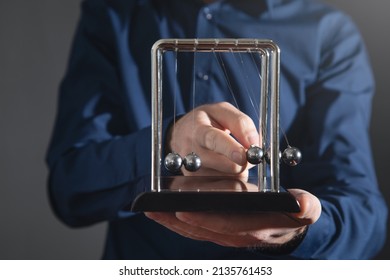 Male Hand Showing Newton's Cradle Balls . Business