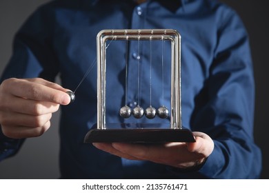 Male Hand Showing Newton's Cradle Balls . Business