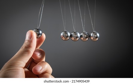 Male Hand Showing Newton's Cradle Balls.