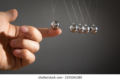 Male Hand Showing Newton's Cradle Balls.