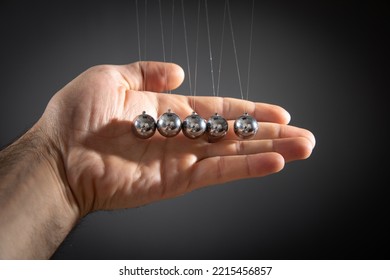 Male Hand Showing Newton's Cradle Balls.