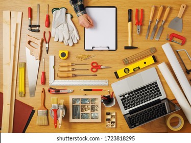 Male Hand Sketching On A White Clipboard Top View, DIY Work Tools All Around, Carpentry And Hobby Concept