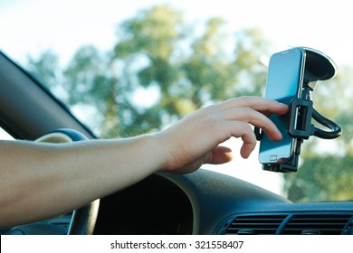Male hand and smartphone in a car