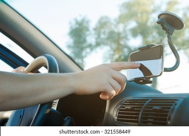 Male hand and smartphone in a car