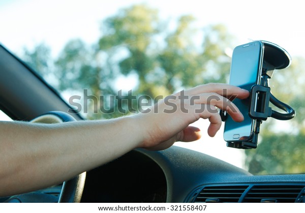 Male hand and smartphone in\
a car