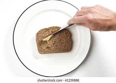 Male Hand Spreading Butter Onto Wholegrain Toast