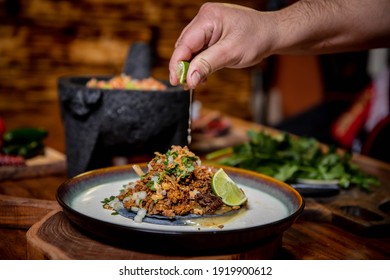 Male Hand Squeezing Fresh Lime On Gourmet Tacos.