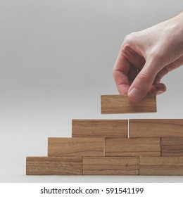 Male Hand Stacking Wooden Blocks. Business Development And Growth Concept
