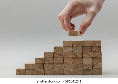 Male Hand Stacking Wooden Blocks. Business Development And Growth Concept
