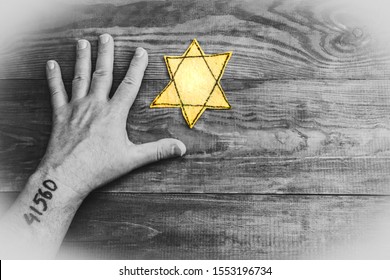 Male hand and star of David on a wooden board background. Holocaust Remembrance Day